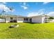 Backyard features a green lawn, a fire pit and privacy fence at 5200 Malaga Ave, Sarasota, FL 34235