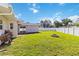 A spacious fenced in backyard with green grass and a fire pit at 5200 Malaga Ave, Sarasota, FL 34235