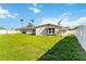Spacious backyard with lush green grass, palm trees and a privacy fence at 5200 Malaga Ave, Sarasota, FL 34235