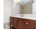 Bathroom featuring cherry wood vanity, a white marble countertop, and shower with updated fixtures at 5200 Malaga Ave, Sarasota, FL 34235