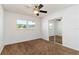 Bright bedroom features neutral carpet, ceiling fan, and sliding closet doors at 5200 Malaga Ave, Sarasota, FL 34235