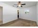 Bedroom showcasing a ceiling fan, neutral walls, and a doorway leading to bathroom with updated fixtures at 5200 Malaga Ave, Sarasota, FL 34235
