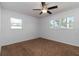 A bright bedroom is carpeted and has two windows and a ceiling fan at 5200 Malaga Ave, Sarasota, FL 34235