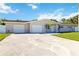 A lovely home featuring a long driveway, two-car garage, and a lush green front yard at 5200 Malaga Ave, Sarasota, FL 34235