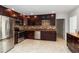 Contemporary kitchen featuring stainless appliances, dark cabinets, tile backsplash and granite countertops at 5200 Malaga Ave, Sarasota, FL 34235