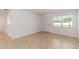 A well-lit living room with neutral tile flooring and fresh, white paint at 5200 Malaga Ave, Sarasota, FL 34235