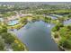 Aerial view showcases a community with a lake, pool, tennis courts, and clubhouse at 5368 Eliseo St, Sarasota, FL 34238