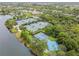 An aerial view showcasing tennis, pickleball, and basketball courts with lush green landscaping in a gated community at 5368 Eliseo St, Sarasota, FL 34238