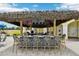 Outdoor bar with a thatched roof, ample seating, and a view of the pool, ideal for outdoor gatherings at 5368 Eliseo St, Sarasota, FL 34238