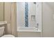 Cozy bathroom featuring blue tile accents, a tub, a shower, and toiletry storage at 5368 Eliseo St, Sarasota, FL 34238
