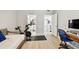 Bedroom featuring light gray walls, wood look flooring, an exercise bike, and desk with monitor at 5368 Eliseo St, Sarasota, FL 34238