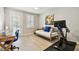 Bedroom featuring light gray walls, wood look flooring, art, an exercise bike, daybed, and desk at 5368 Eliseo St, Sarasota, FL 34238