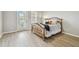 Bedroom with wood look tile, door to balcony, wooden bed frame, and neutral colored walls at 5368 Eliseo St, Sarasota, FL 34238