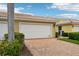 Two car garage with a brick driveway and trimmed bushes at 5368 Eliseo St, Sarasota, FL 34238