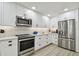 A chef-inspired kitchen with a stainless steel range, microwave, and refrigerator surrounded by white cabinets at 5368 Eliseo St, Sarasota, FL 34238