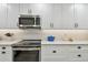Close-up of a kitchen featuring modern appliances, white cabinets, a decorative backsplash, and recessed lighting at 5368 Eliseo St, Sarasota, FL 34238