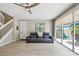 Bright living room featuring a gray leather sofa, a ceiling fan, and sliding glass doors to the outdoor patio at 5368 Eliseo St, Sarasota, FL 34238