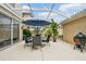 Inviting patio under a screened enclosure, featuring a dining set and a grill at 5368 Eliseo St, Sarasota, FL 34238