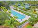 A beautiful pool area with landscaping, lounge chairs, tables, umbrellas, and access to tennis and bocce ball courts at 5368 Eliseo St, Sarasota, FL 34238