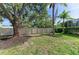 Green backyard with mulch beds, mature trees, and a modern fence for privacy at 5508 83Rd E Ter, Sarasota, FL 34243