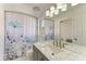 Bathroom with a marble countertop, floral shower curtain, and updated vanity lighting at 5508 83Rd E Ter, Sarasota, FL 34243