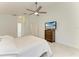 Well-lit bedroom with white marble floors, ceiling fan, and a view of the ensuite bathroom at 5508 83Rd E Ter, Sarasota, FL 34243