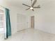Bright bedroom with white marble floors, ceiling fan, closet, and open doorway at 5508 83Rd E Ter, Sarasota, FL 34243