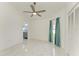 Spacious bedroom featuring white marble floors, ceiling fan, and ensuite bathroom view at 5508 83Rd E Ter, Sarasota, FL 34243