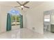 Bedroom features a large window, modern ceiling fan, and ensuite bathroom at 5508 83Rd E Ter, Sarasota, FL 34243