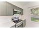 Close-up of updated kitchen appliances with stainless steel microwave and stove, and white countertop at 5508 83Rd E Ter, Sarasota, FL 34243