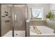 Bright bathroom featuring a separate shower and soaking tub with a view of a green space outside at 5644 Flagstone Trl, Palmetto, FL 34221