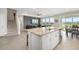 Open kitchen area featuring island, white cabinets and large windows overlooking backyard at 5644 Flagstone Trl, Palmetto, FL 34221