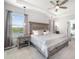 Bright and airy main bedroom with tray ceiling, fan, and elegant lake views at 5644 Flagstone Trl, Palmetto, FL 34221