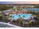 Aerial view of a large community pool with palm trees and lounge areas at 5644 Flagstone Trl, Palmetto, FL 34221