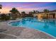 Relaxing pool area with lounge chairs and covered seating at dusk at 5644 Flagstone Trl, Palmetto, FL 34221