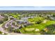 Aerial view of the community featuring a golf course, lake, clubhouse, and homes amidst lush landscaping at 6310 Green Oak Cir, Bradenton, FL 34203