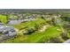 Aerial view of a lush golf course featuring manicured greens, sand traps, and scenic water hazards, with homes and trees around it at 6310 Green Oak Cir, Bradenton, FL 34203