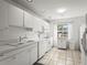 Bright kitchen featuring white cabinetry, appliances, and a window with natural light at 6310 Green Oak Cir, Bradenton, FL 34203