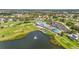 Scenic aerial view of a golf course community featuring a clubhouse, swimming pool, tennis courts, and a pond with a fountain at 6310 Green Oak Cir, Bradenton, FL 34203