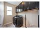 Convenient laundry room with modern washer and dryer, plus overhead storage cabinets at 6377 Mighty Eagle Way, Sarasota, FL 34241