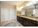 Elegant bathroom featuring dual sinks with granite countertops, dark cabinetry, and tile floors at 6377 Mighty Eagle Way, Sarasota, FL 34241