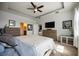 Spacious main bedroom showcasing dual dressers, tray ceilings, and a TV mounted to the wall at 6377 Mighty Eagle Way, Sarasota, FL 34241