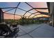 Screened in pool with lounge chairs, basketball hoop, and lush landscaping in the backyard at 6377 Mighty Eagle Way, Sarasota, FL 34241