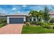 Charming single-story home featuring a paver driveway, lush landscaping, and a neutral color palette at 6714 Alstead Cir, Bradenton, FL 34202