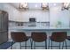 Modern kitchen with white cabinets, stainless steel appliances, island seating, and stylish backsplash at 6714 Alstead Cir, Bradenton, FL 34202