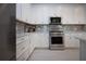 Clean kitchen with white cabinets and stainless steel appliances including a microwave and oven at 6714 Alstead Cir, Bradenton, FL 34202