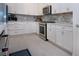 Well-appointed kitchen boasts stainless steel appliances, white cabinets, light countertops, and modern backsplash at 6714 Alstead Cir, Bradenton, FL 34202