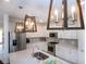 Bright kitchen features stainless steel appliances, white cabinetry, stylish pendant lights, and stone countertops at 6714 Alstead Cir, Bradenton, FL 34202