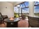 Covered lanai with brick pavers and an outdoor gas fire pit overlooking a scenic lake at 6714 Alstead Cir, Bradenton, FL 34202