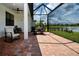 Screened-in lanai with brick pavers, seating area, and views of the serene lake at 6714 Alstead Cir, Bradenton, FL 34202